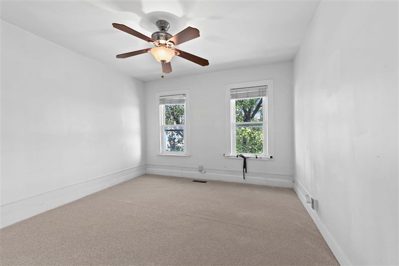 Second-floor room with two windows and a ceiling fan