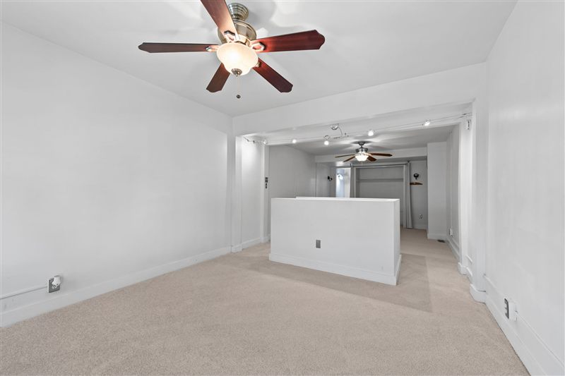 Second floor with a half wall and a second ceiling fan
