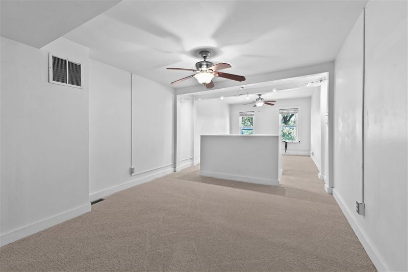 Open second floor with carpet and a ceiling fan