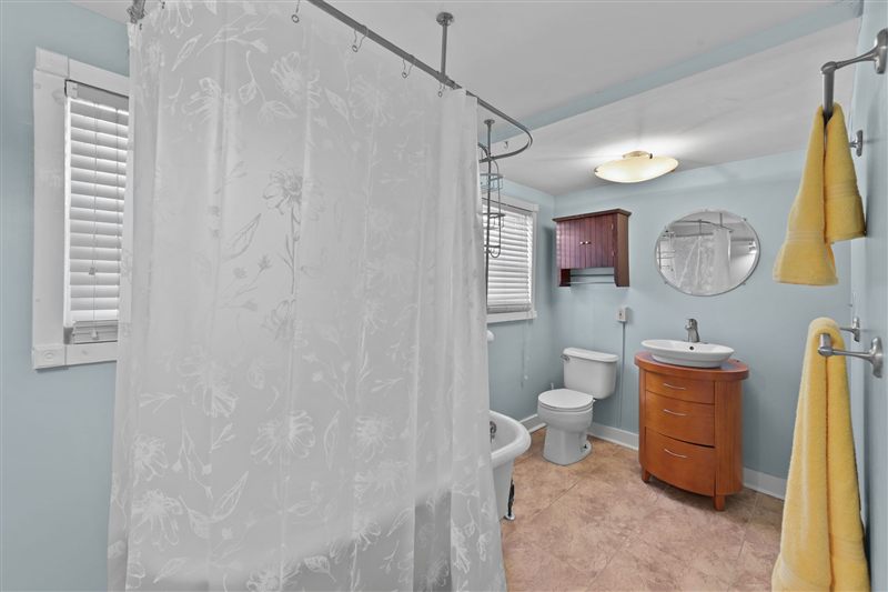 Large private full bath with a tub, vanity, and two windows