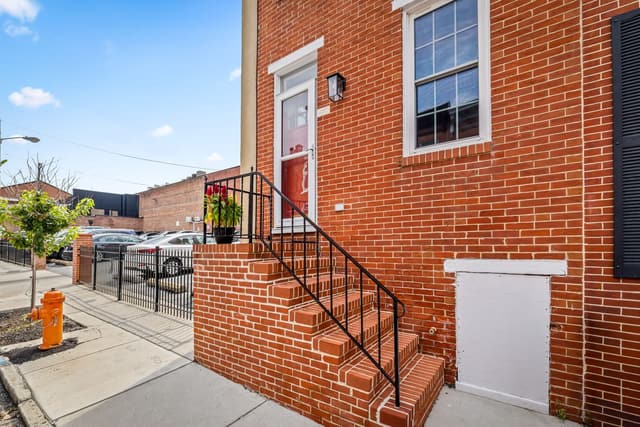 Brick steps and iron railing leading to the front door