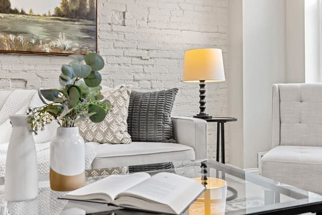 Living room seating area with a painted brick wall