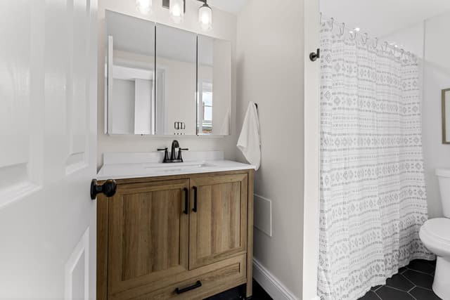 Bathroom with a wood vanity and mirrored medicine cabinet