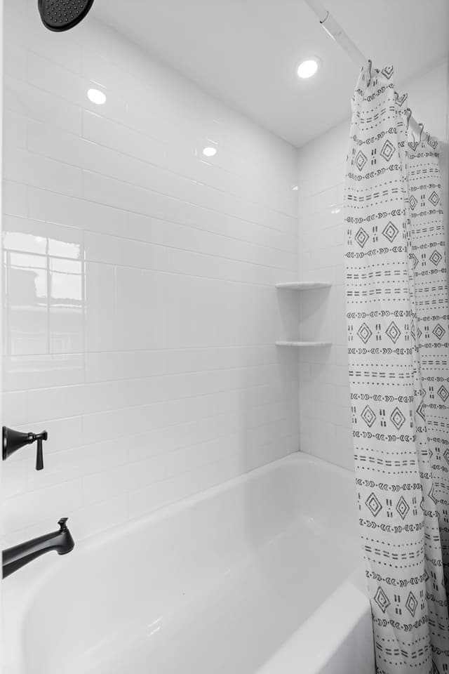 Bathroom with a new white tiled tub and shower