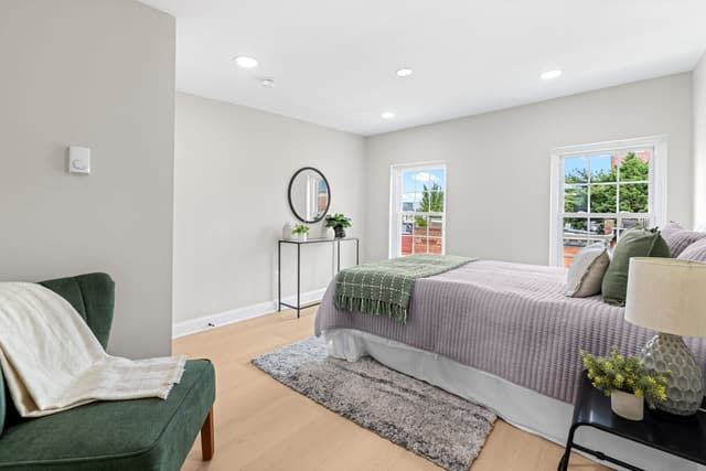 Second bedroom with an accent chair and two windows