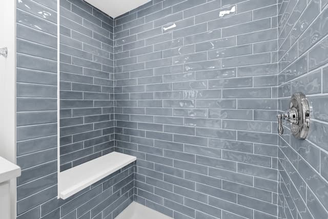 Blue tiled shower with a built-in ledge