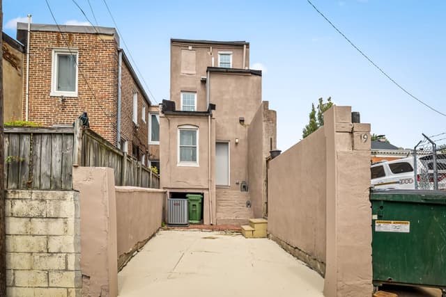 Private concrete parking pad behind the home between two walls