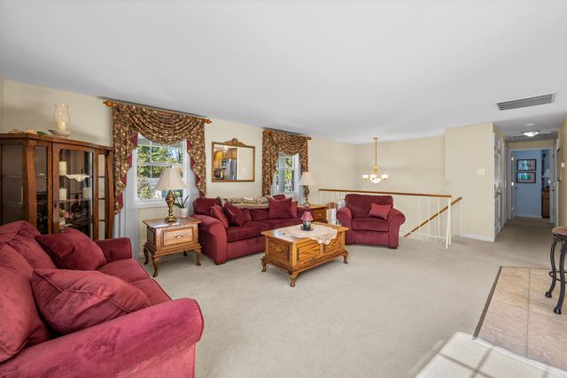Living room with large front windows and a view toward the dining area
