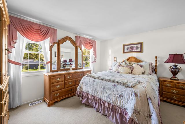 Bedroom with a dresser and two windows