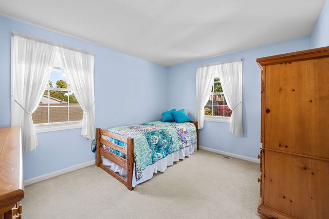 Bedroom with two windows and a wardrobe